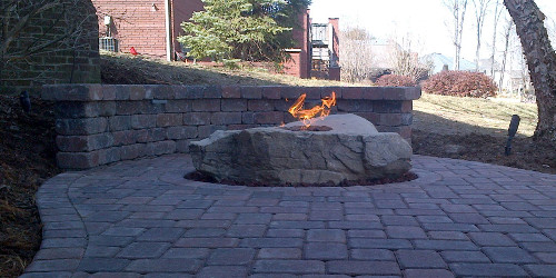 Paver patio with seat wall and fire boulder